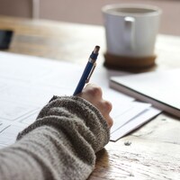 Person Holding Orange Pen